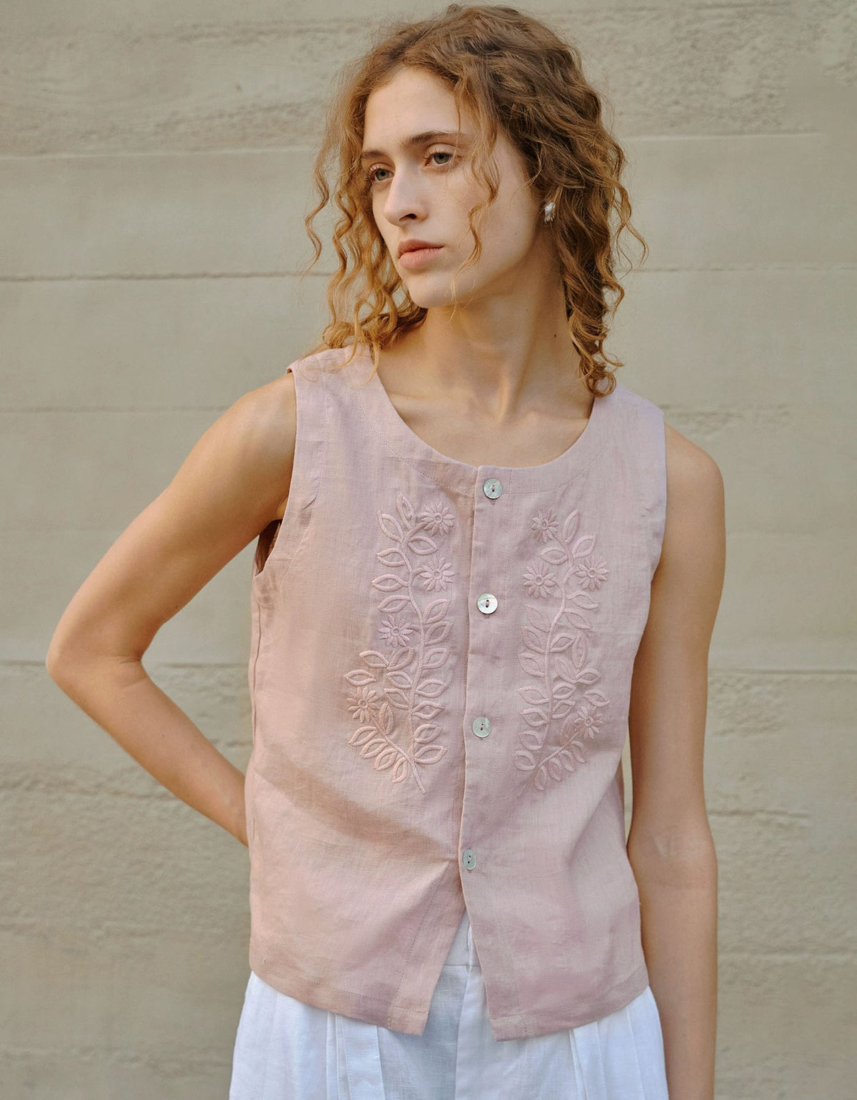 woman wearing pink embroidered linen sleeveless blouse front view