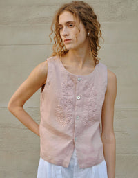 woman wearing pink embroidered linen sleeveless blouse front view