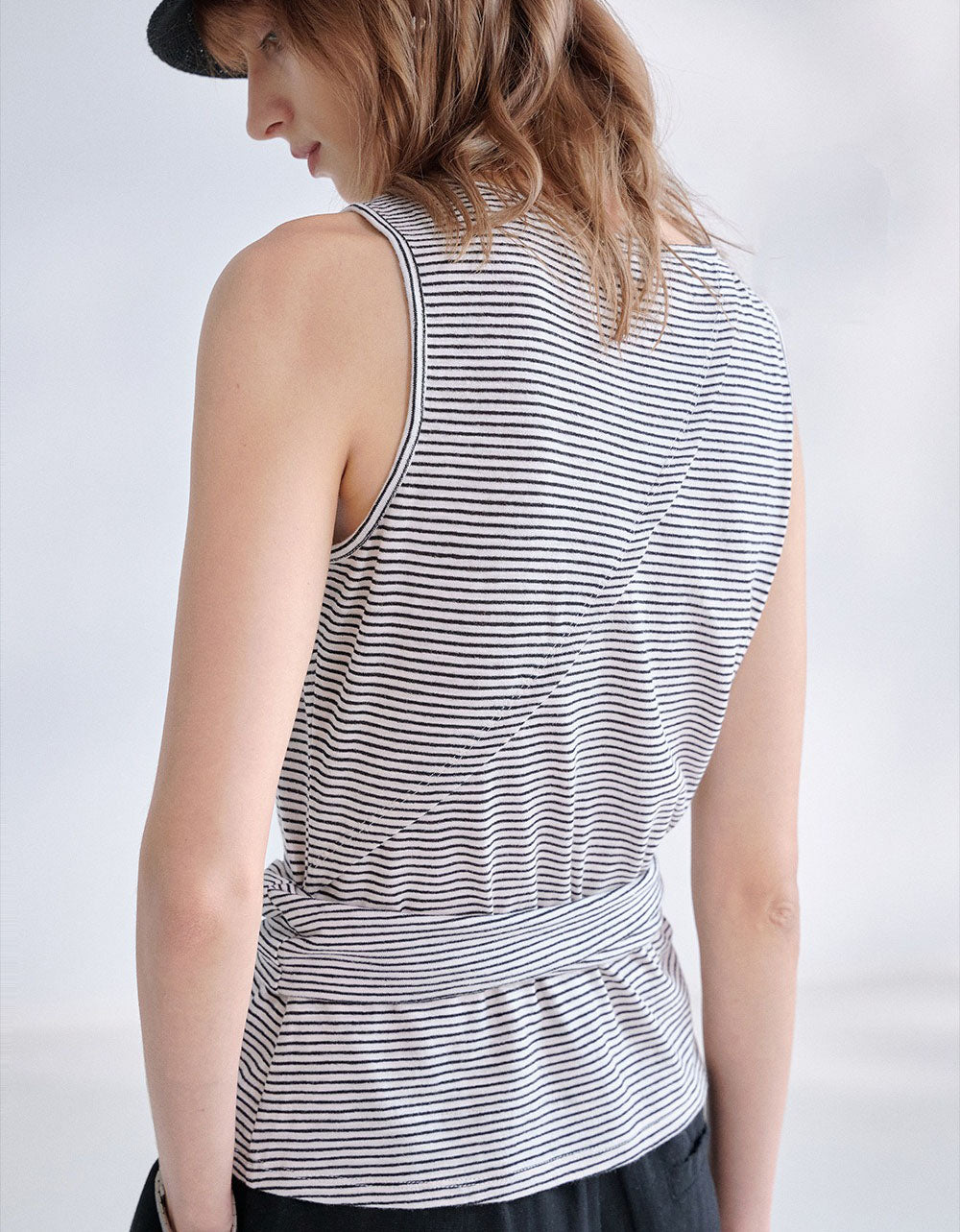 Minimalist striped knit camisole for women paired with black wide leg pants