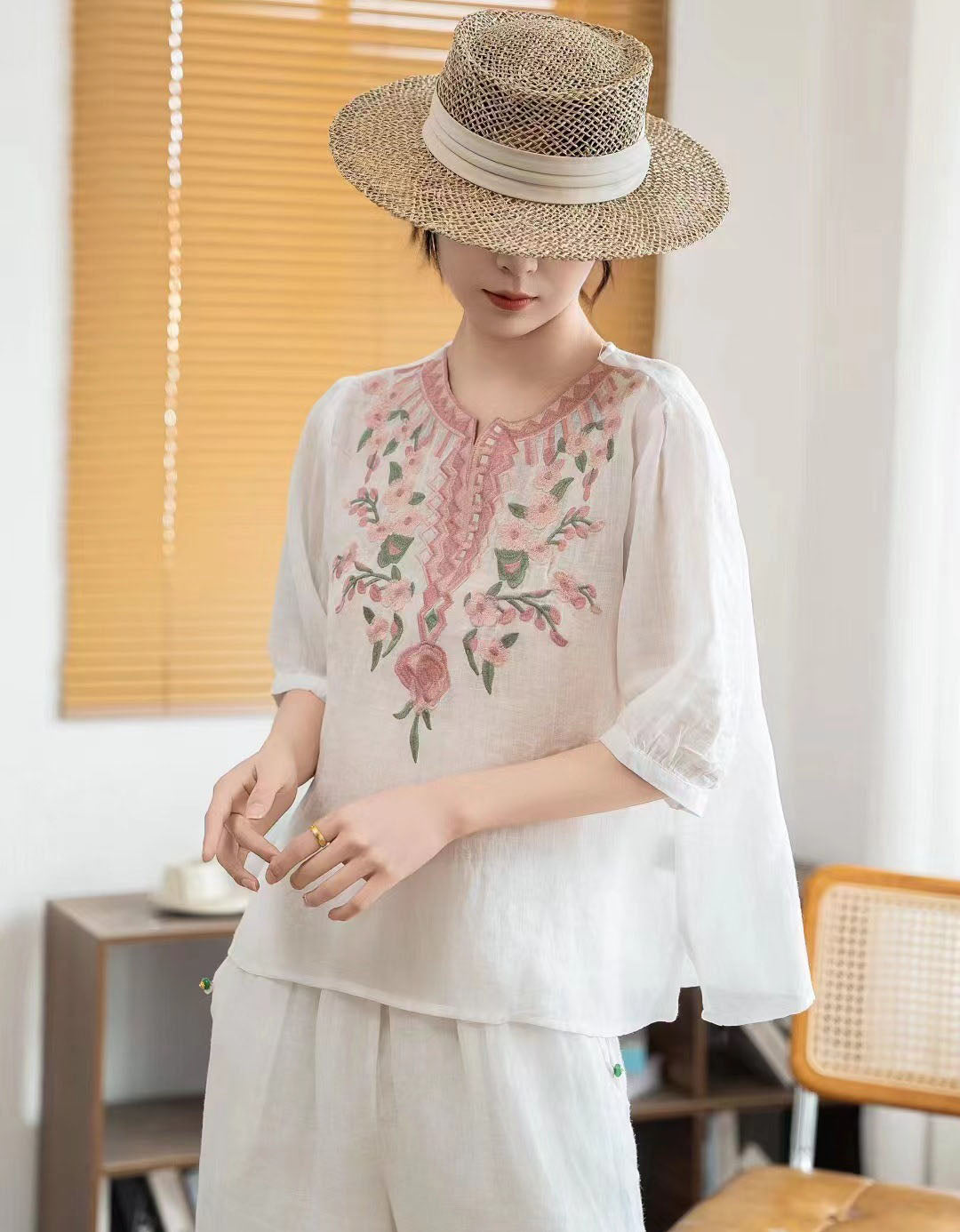 Women white linen blouse featuring floral embroidery neckline detail