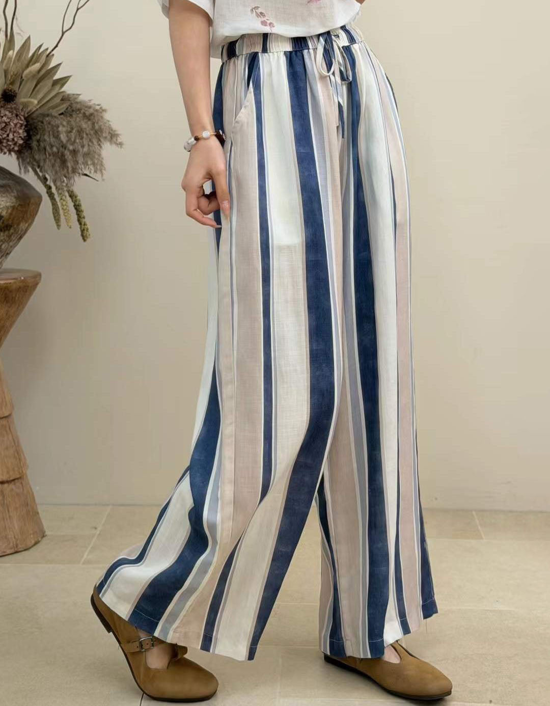 Side view of women's colorful striped palazzo pants featuring relaxed wide leg silhouette