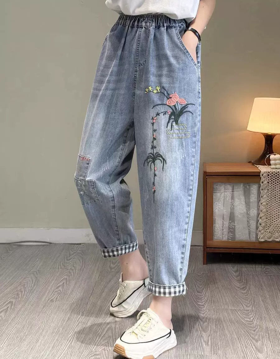 Side view of cuffed hem elastic waist denim jogger pants with floral design