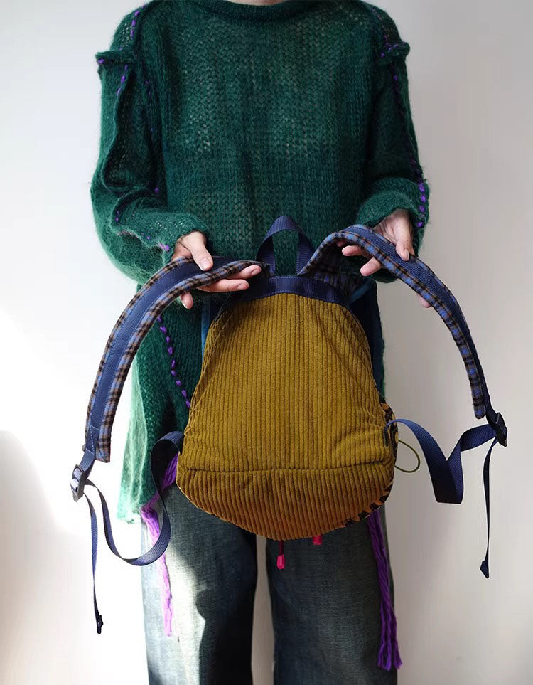 Retro plaid women’s backpack styled with green knit sweater and beret for fall outfit