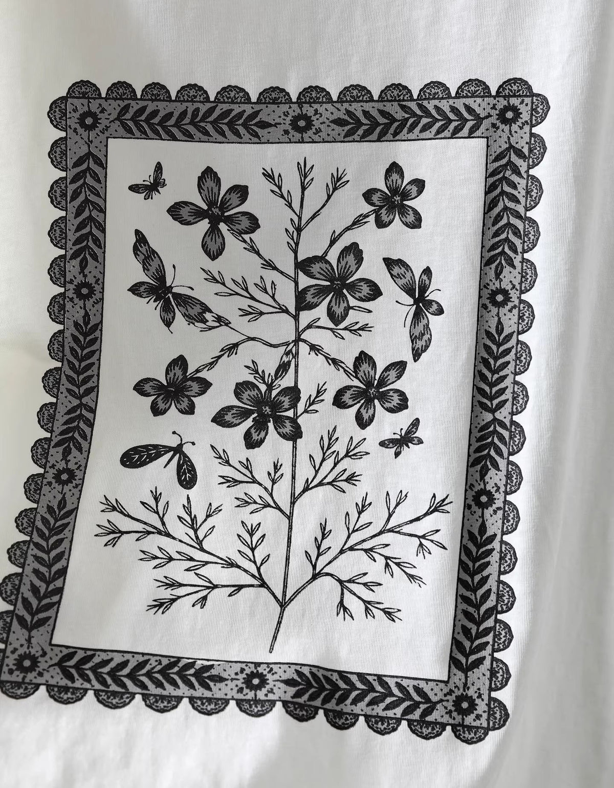 Close up of vintage botanical artwork on soft white graphic t-shirt