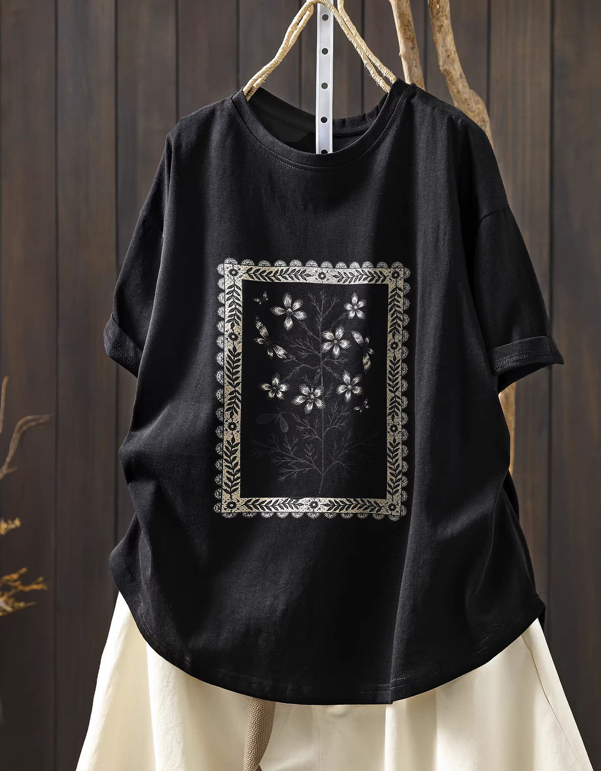 Front view of black oversized floral graphic t-shirt with vintage botanical print

