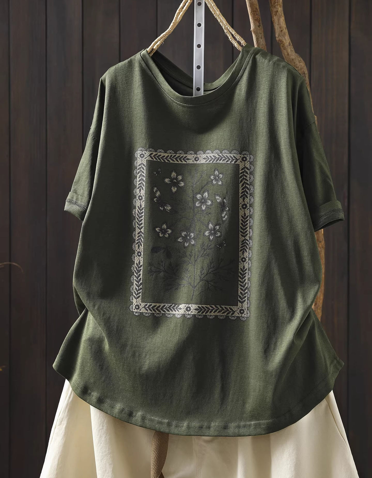 Green t-shirt with floral design on a wooden background