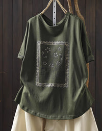 Green t-shirt with floral design on a wooden background