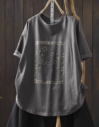 Gray t-shirt with floral embroidery on a wooden background