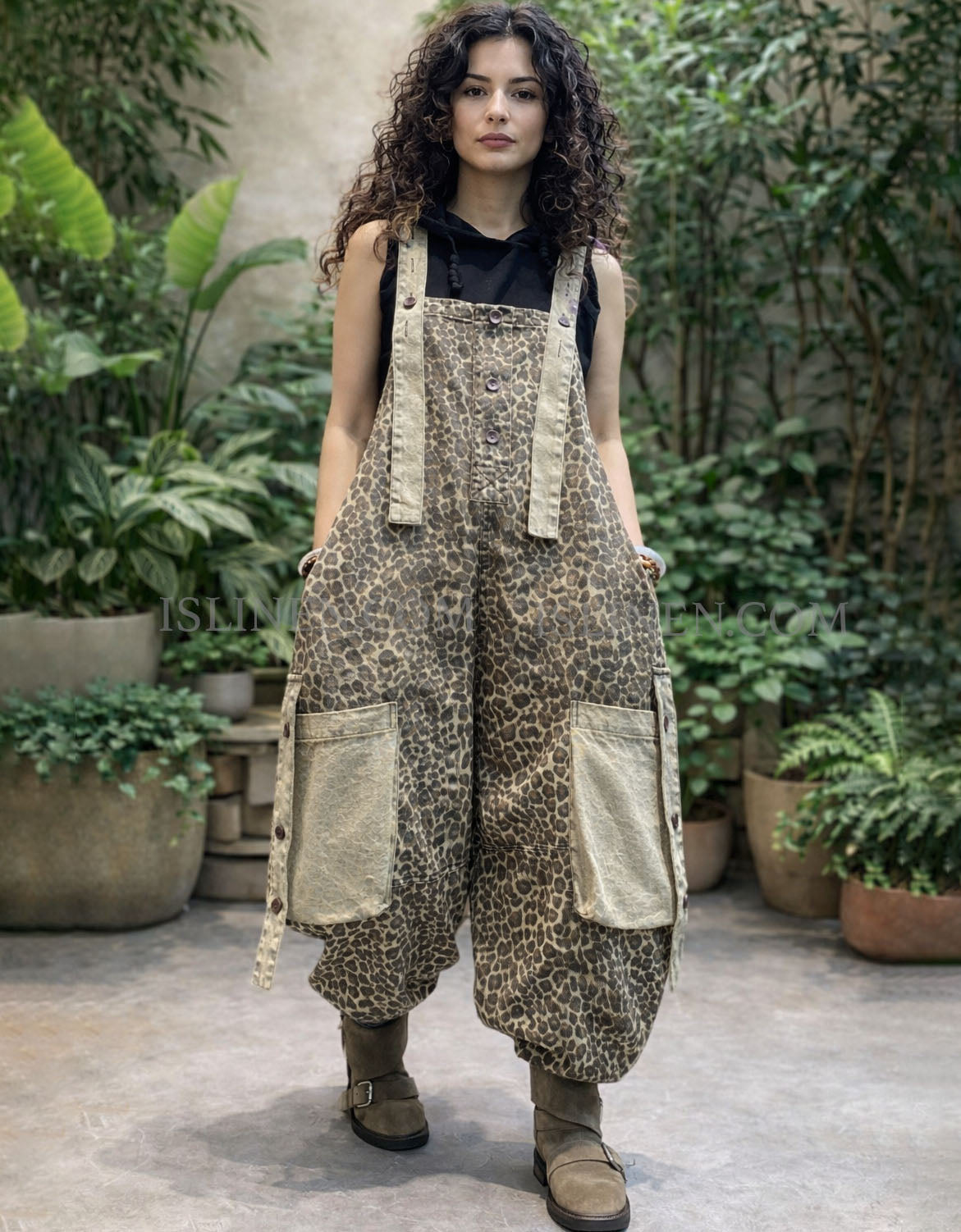Front view of loose leopard bib overalls styled with black top