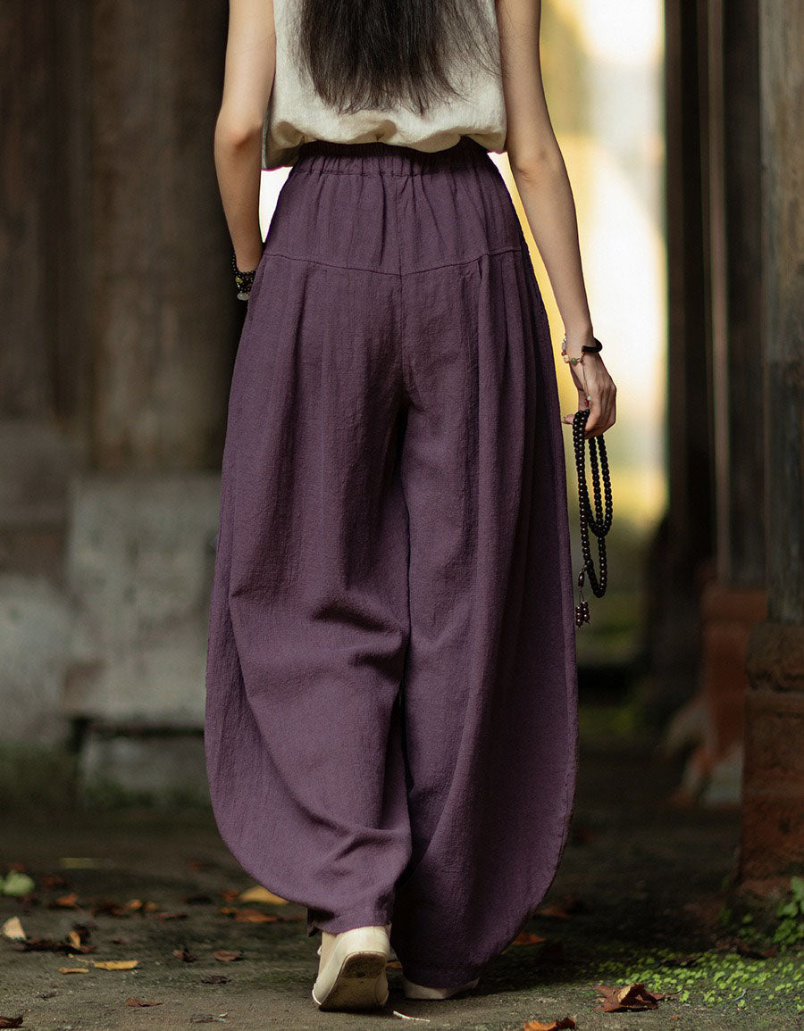 Back view of purple linen harem pants with gathered waistband and loose draped legs.