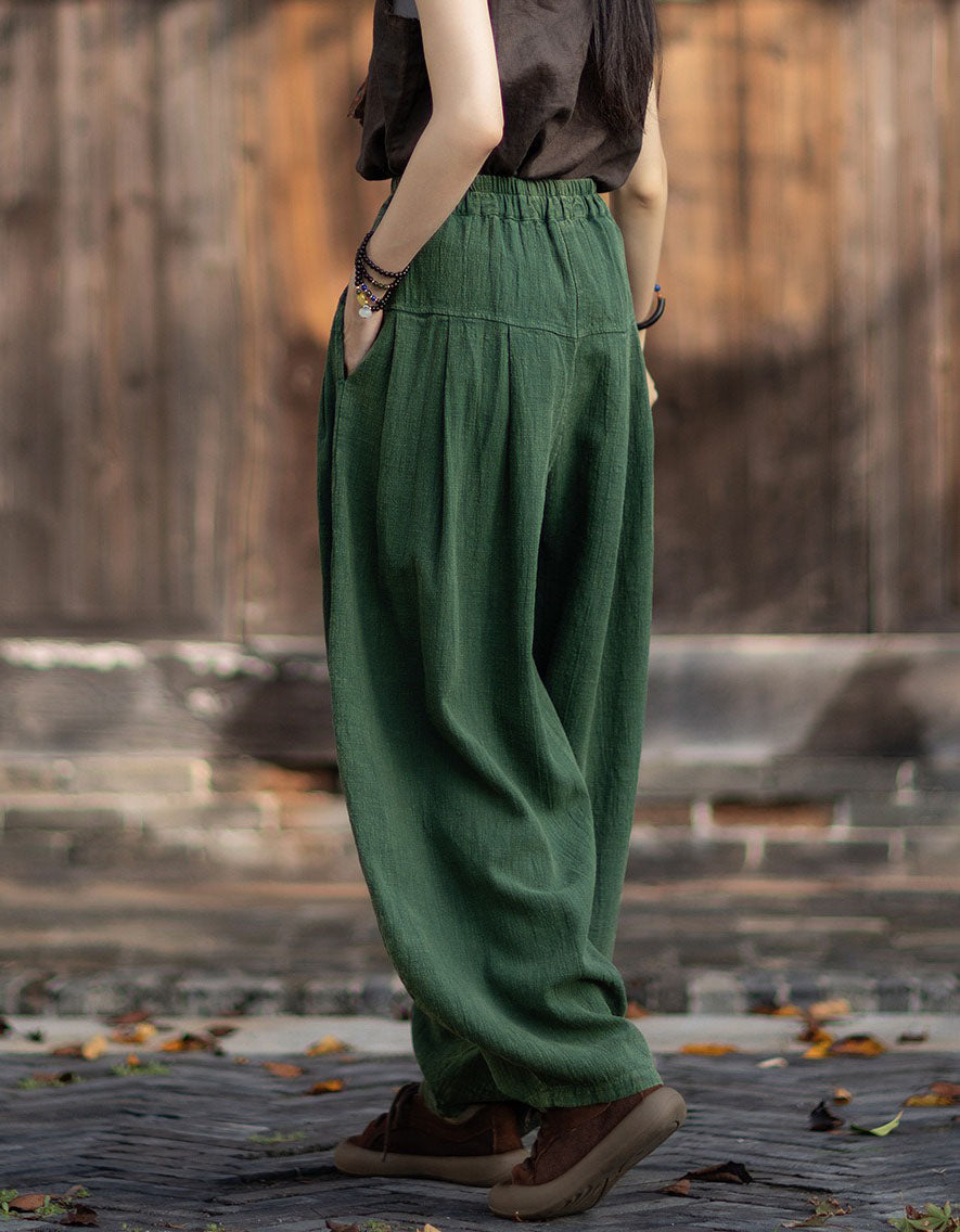 Person wearing green wide-leg pants with a blurred background