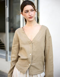 Woman wearing a beige cardigan in an outdoor setting