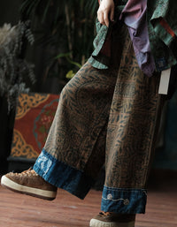 Woman wearing boho printed wide leg palazzo pants with brown ethnic pattern and dark blue contrast hem indoors