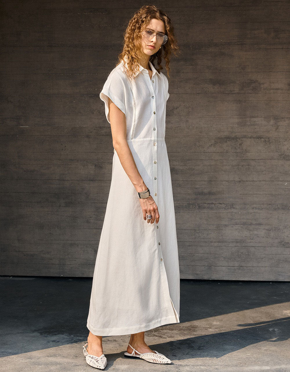 Minimalist beige shirt dress styled with woven handbag and sandals