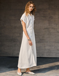 Minimalist beige shirt dress styled with woven handbag and sandals