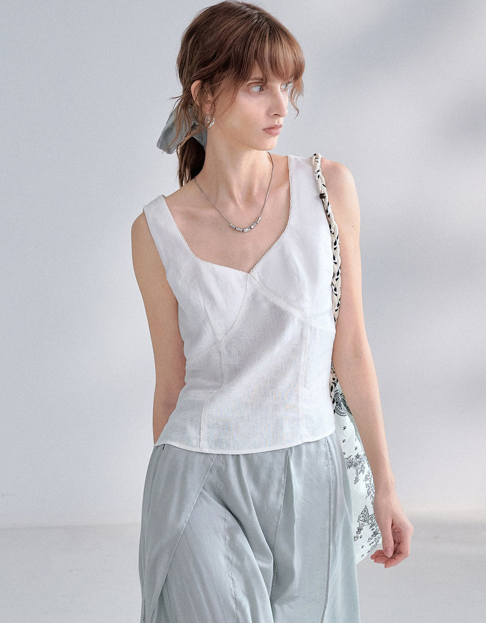 Black sleeveless linen top paired with white pants