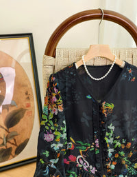 Front view of women's black floral midi dress featuring long sleeves and lightweight chiffon fabric
