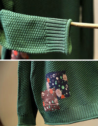 Close-up of textured knit fabric and patchwork detail on red women’s sweater