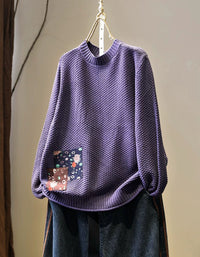 Women’s purple textured knit sweater with patchwork detail, front view