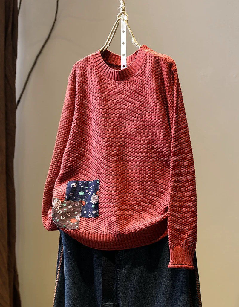 Women’s red long sleeve knit pullover styled with dark denim jeans