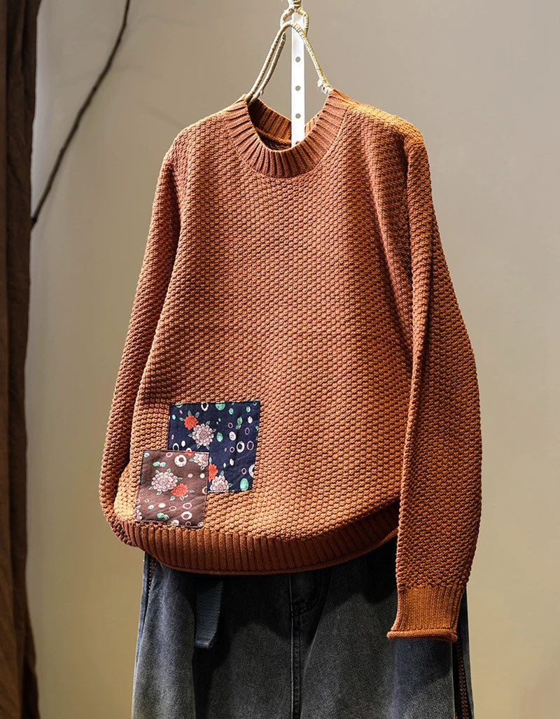 Women’s orange long sleeve knit pullover styled with dark denim jeans