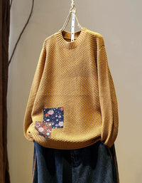 Women’s yellow long sleeve knit pullover styled with dark denim jeans
