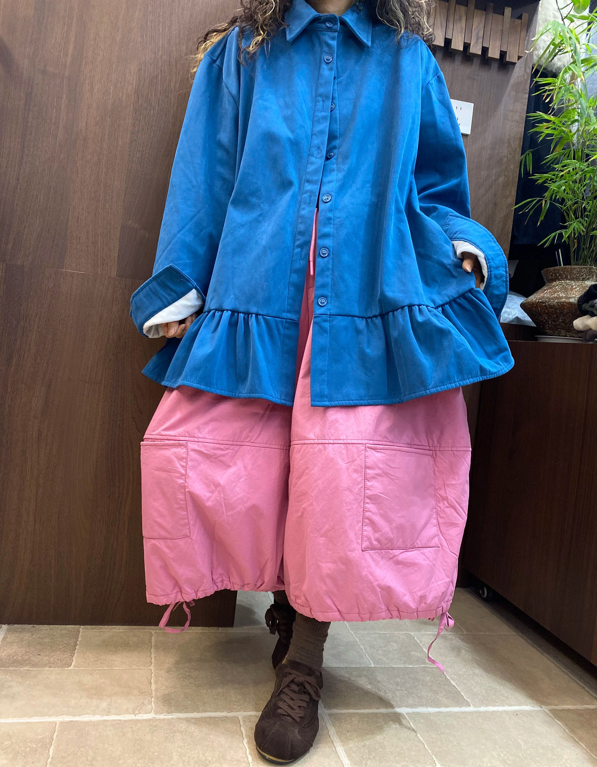 Wide sleeve cuffs with contrasting white inner cuffs on an oversized blue women's shirt.