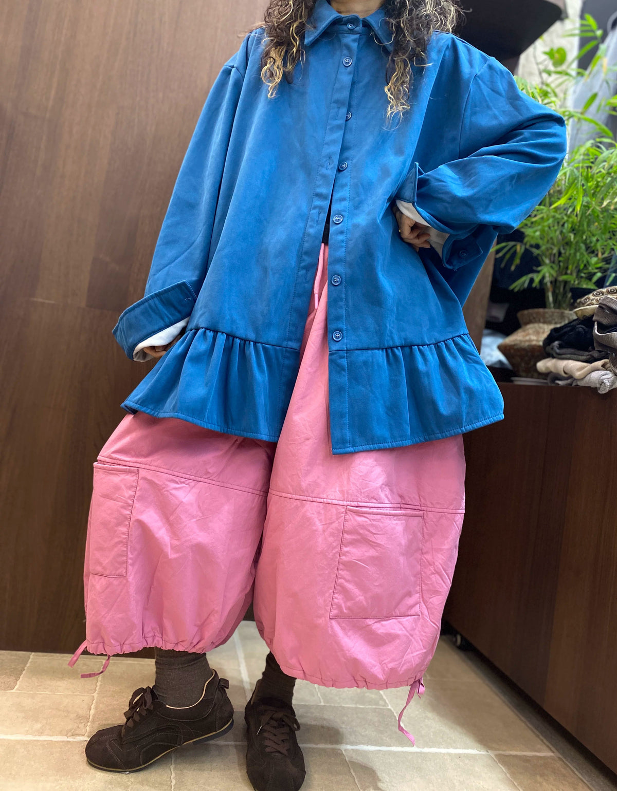 Wide sleeve cuffs with contrasting white inner cuffs on an oversized blue women's shirt.