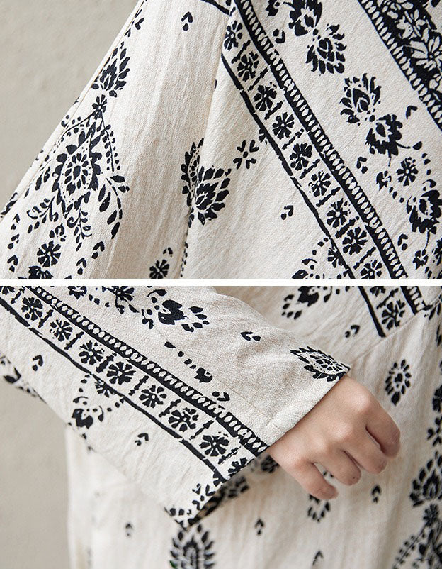 Close-up of a white garment with black floral patterns on a neutral background