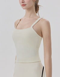 Woman wearing a beige tank top against a plain background