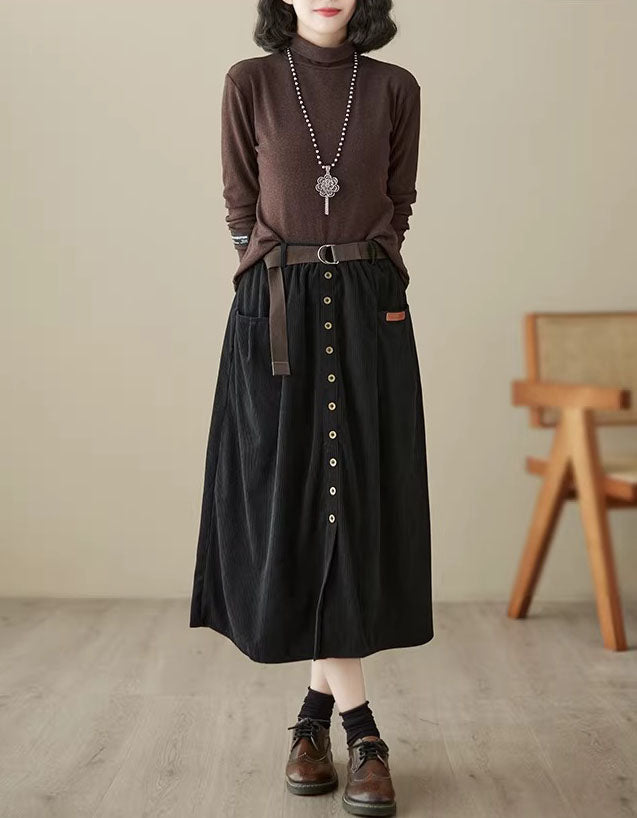 Women’s black corduroy skirt with belt, button front, and side slits, providing a fashionable and comfortable casual look