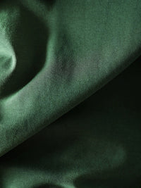 Detail view of the dark green sweater's high neckline and fabric texture
