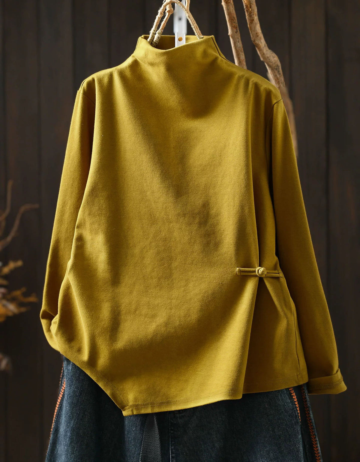 Yellow women's high neck sweater with asymmetrical hem and side button detail