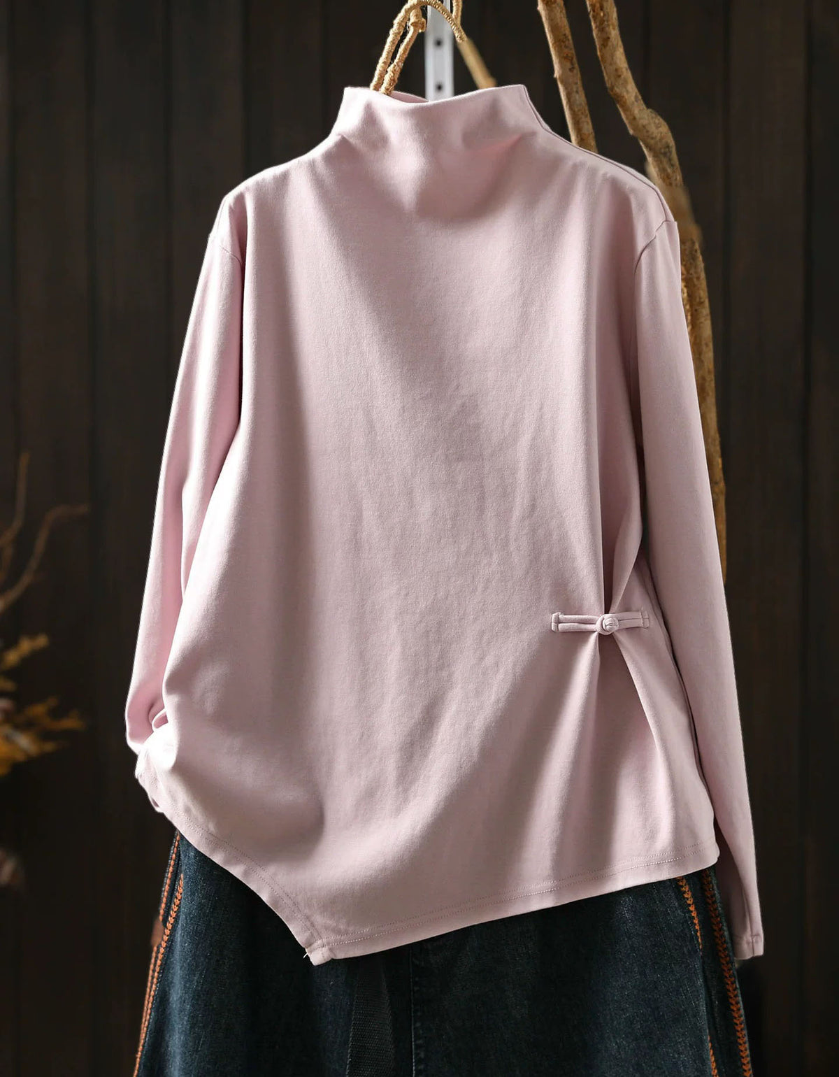 Pink women's high neck sweater with asymmetrical hem and side button detail