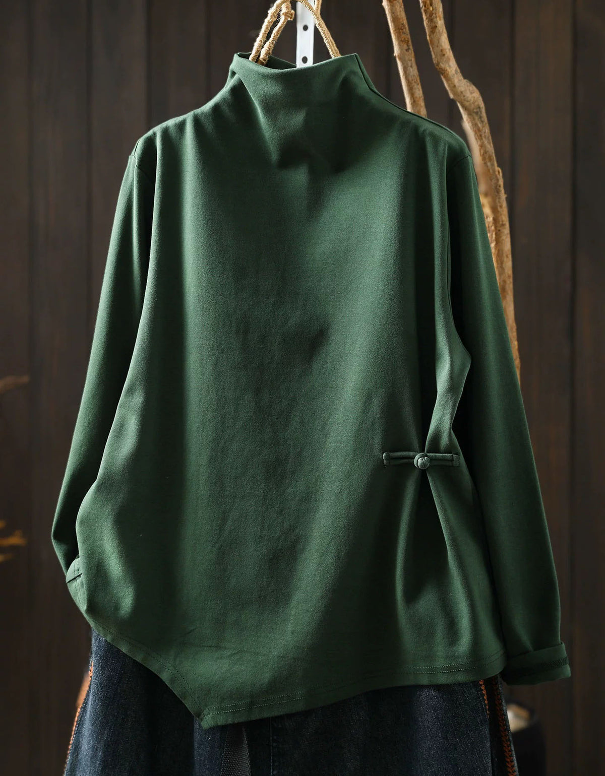 Green women's high neck sweater with asymmetrical hem and side button detail