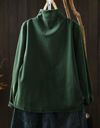 Back view of dark green women's high neck sweater with asymmetrical hem and side button detail