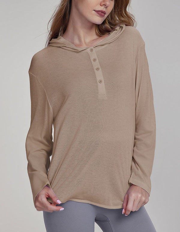 Woman wearing a beige long-sleeve shirt with buttons on a plain background