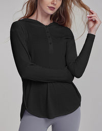 Woman wearing a black long-sleeve top with a plain background