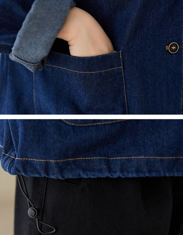 Close-up of a person wearing a blue denim jacket with a pocket.