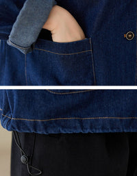 Close-up of a person wearing a blue denim jacket with a pocket.