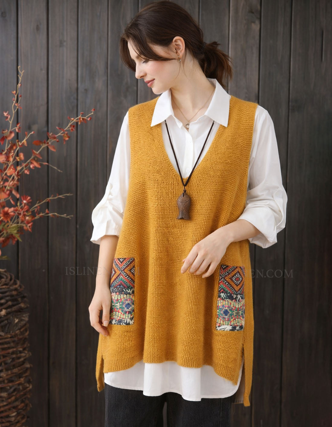 Front view of women’s sleeveless knit sweater vest layered over a shirt