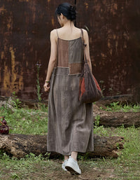 Woman in a long, patterned dress standing in a rustic outdoor setting with a rusted metal wall.