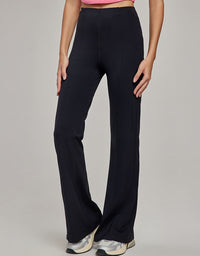 Person wearing black wide-leg pants on a plain background