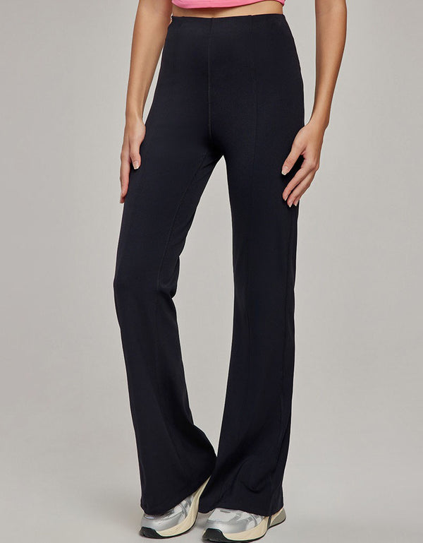 Person wearing black wide-leg pants on a plain background