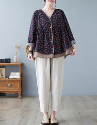 Person wearing a floral blouse and beige pants in a room with a gray wall and wooden furniture.