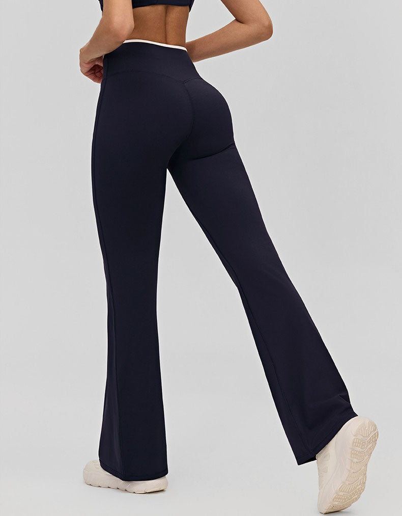 Person wearing navy blue flared pants on a light gray background back view