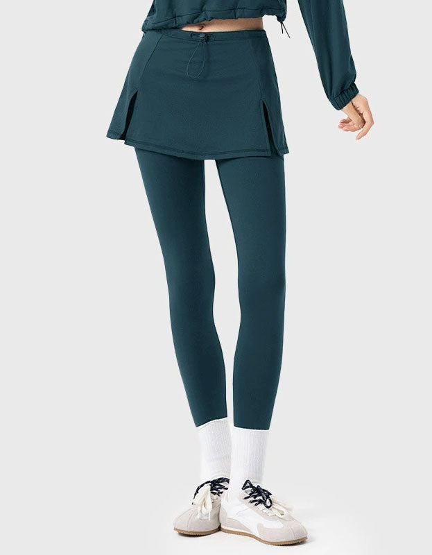 Person wearing teal athletic pants and jacket on a white background