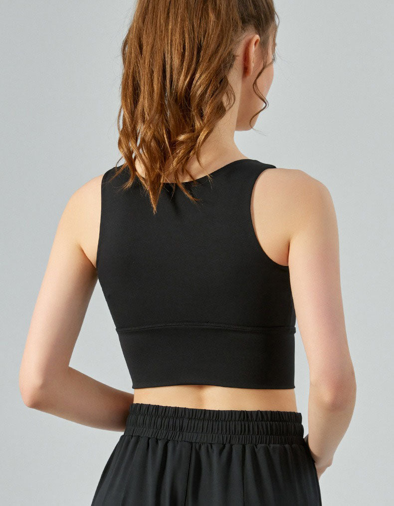 Person wearing a black sports bra and black pants on a gray background