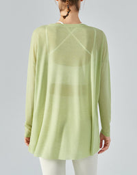 Light green long-sleeve top worn by a person on a plain background back view