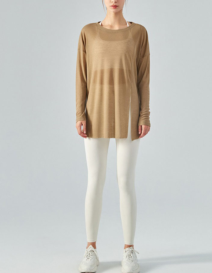 Person wearing a brown long-sleeve top and white leggings on a gray background